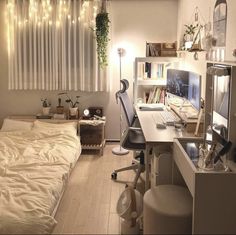 a bedroom with a bed, desk and computer on top of the desk in front of a window