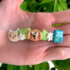 a hand holding three different toy animals in it's palm, one is blue and the other is green