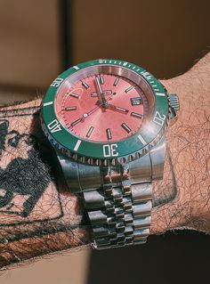 a man wearing a red and green watch on his arm