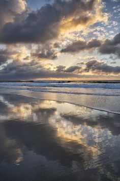 the sky is reflected in the wet sand