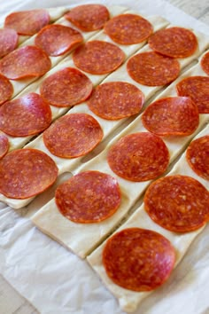 several slices of pepperoni are arranged on top of each other in order to make a pizza