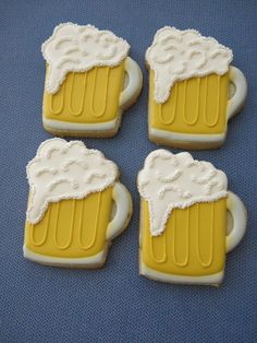 four decorated cookies in the shape of beer mugs