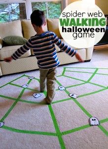 a young boy standing on top of a green and white rug next to a couch