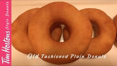 three doughnuts sitting on top of a white plate next to each other with the words old fashioned plain donuts