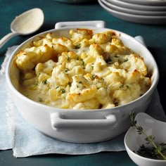 a white casserole dish filled with macaroni and cheese on a table