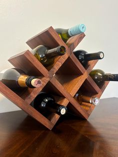 a wooden wine rack filled with bottles on top of a table