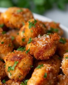 a white bowl filled with fried food and garnished with parmesan cheese