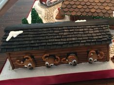 a gingerbread house made to look like it has eyes and nose on the roof