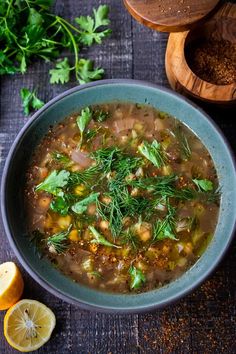 a bowl filled with soup next to sliced lemons and parsley