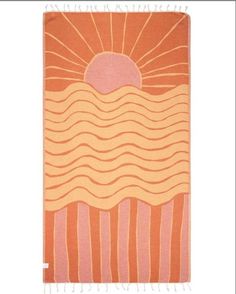 an orange and pink beach towel with the sun in the sky over water on it