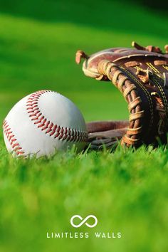 a baseball mitt and ball laying on the grass in front of a green field