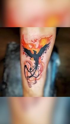 a tattoo on the leg of a person with an orange and black bird on it