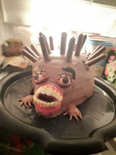 a cake shaped like an animal with teeth and claws on it's head is shown