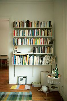 a bookshelf filled with lots of books in a room