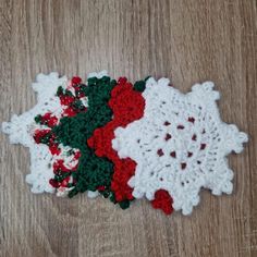 crocheted snowflakes with red, white and green trim on wooden surface