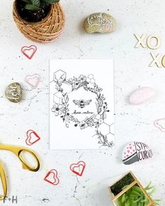 a card with the word love surrounded by hearts and other decorations on a white surface