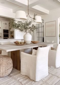 a dining room table with white chairs around it