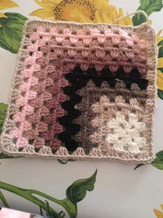 a crocheted square with flowers on it