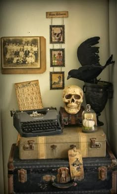 an old fashioned typewriter sitting on top of suitcases next to a skull head