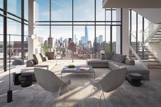 a large living room with high ceilings and floor to ceiling windows overlooking new york city