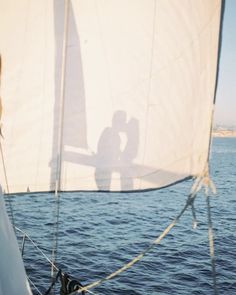 the shadow of a man and woman on a sailboat