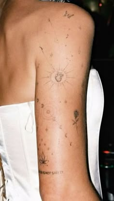 the back of a woman's arm with tattoos on it