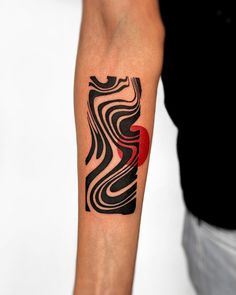 a man with a tattoo on his arm that has wavy lines and a red dot