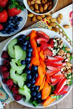 two bowls filled with fruit and nuts on top of a table