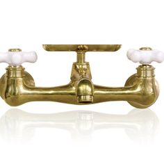 a brass faucet with two white handles