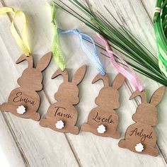 four wooden easter bunnies with name tags on them