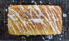 a loaf of lemon bread with icing on a cooling rack