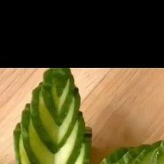 a cucumber cut in half on top of a wooden table