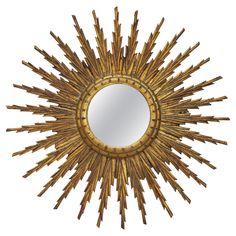 a mirror that is sitting on top of a wooden table and it looks like a sunburst