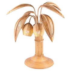 a wicker table lamp with two lights on each side and a palm tree in the middle