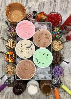 an assortment of ice creams and desserts are arranged in a square on a marble surface