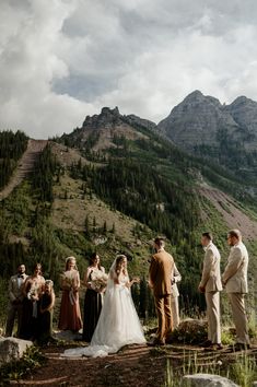 a bride and groom are getting married in the mountains