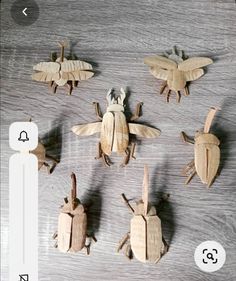 six wooden bugs sitting on top of a table