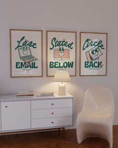 a white chair sitting in front of two posters on the wall next to a dresser