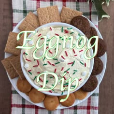 an eggnog dip in a bowl surrounded by cookies and crackers