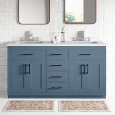 a bathroom vanity with two mirrors above it and rugs on the floor next to it