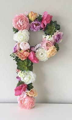 the letter f is made up of flowers and greenery on top of a table