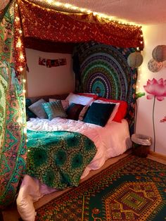 a bed that has been decorated with lights and blankets on top of it, next to a rug