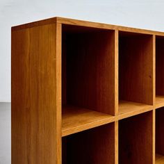 a wooden shelf with six compartments on each side and no one in the room behind it