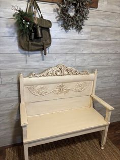 a bench in front of a wooden wall with two wreaths on the wall above it