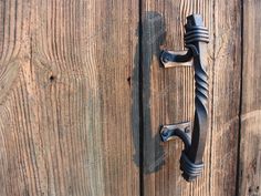 an iron door handle on a wooden door