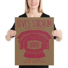 a woman is holding up a poster for levi's stadium