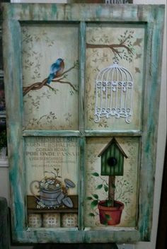 an old window decorated with birds, flowers and birdcage on it's side