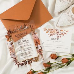 the wedding stationery is laid out on top of the bed with flowers and lace