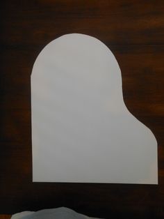 a white piece of paper sitting on top of a wooden table next to a bed