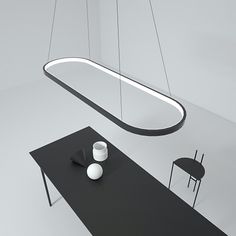 a black table with two white vases sitting on top of it next to a hanging light fixture